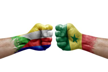 Two hands punch to each others on white background. Country flags painted fists, conflict crisis concept between comoros and senegal