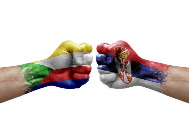 Two hands punch to each others on white background. Country flags painted fists, conflict crisis concept between comoros and serbia