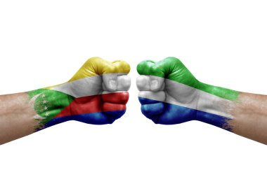 Two hands punch to each others on white background. Country flags painted fists, conflict crisis concept between comoros and sierra leone