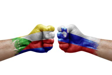 Two hands punch to each others on white background. Country flags painted fists, conflict crisis concept between comoros and slovenia