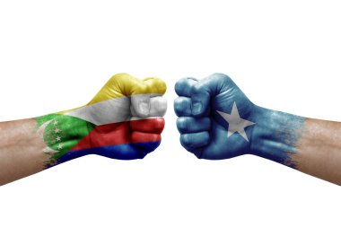 Two hands punch to each others on white background. Country flags painted fists, conflict crisis concept between comoros and somalia