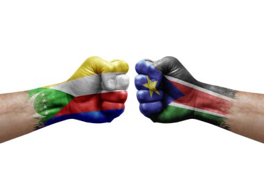 Two hands punch to each others on white background. Country flags painted fists, conflict crisis concept between comoros and south sudan