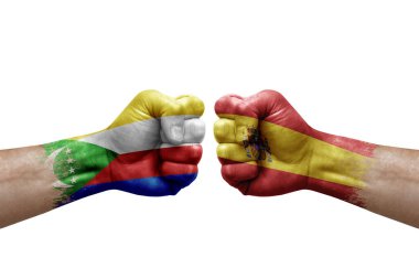 Two hands punch to each others on white background. Country flags painted fists, conflict crisis concept between comoros and spain