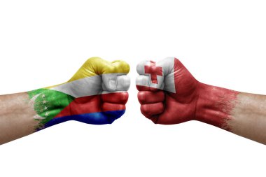 Two hands punch to each others on white background. Country flags painted fists, conflict crisis concept between comoros and tonga