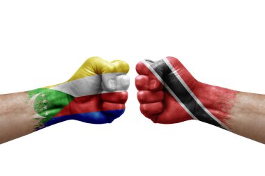 Two hands punch to each others on white background. Country flags painted fists, conflict crisis concept between comoros and tobago