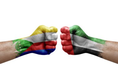 Two hands punch to each others on white background. Country flags painted fists, conflict crisis concept between comoros and united arab emirates