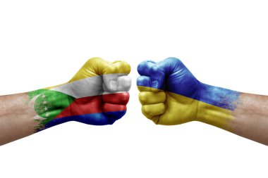 Two hands punch to each others on white background. Country flags painted fists, conflict crisis concept between comoros and ukraine