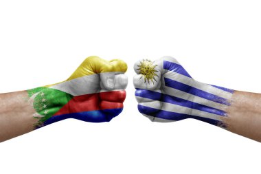 Two hands punch to each others on white background. Country flags painted fists, conflict crisis concept between comoros and uruguay