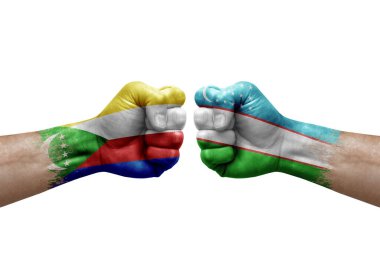 Two hands punch to each others on white background. Country flags painted fists, conflict crisis concept between comoros and uzbekistan