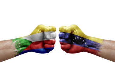 Two hands punch to each others on white background. Country flags painted fists, conflict crisis concept between comoros and venezuela