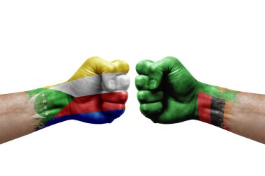 Two hands punch to each others on white background. Country flags painted fists, conflict crisis concept between comoros and zambia