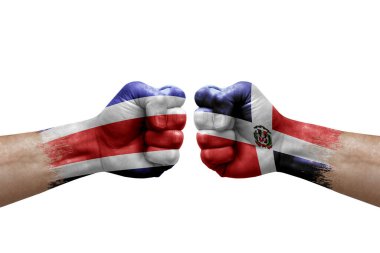 Two hands punch to each others on white background. Country flags painted fists, conflict crisis concept between costa rica and dominican republic