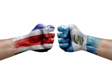 Two hands punch to each others on white background. Country flags painted fists, conflict crisis concept between costa rica and guatemala