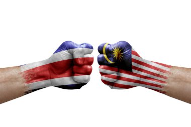 Two hands punch to each others on white background. Country flags painted fists, conflict crisis concept between costa rica and malaysia