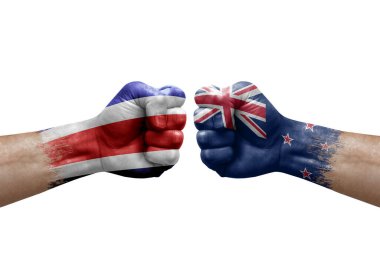Two hands punch to each others on white background. Country flags painted fists, conflict crisis concept between costa rica and new zealand