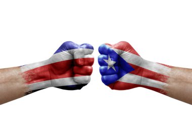 Two hands punch to each others on white background. Country flags painted fists, conflict crisis concept between costa rica and puerto rico