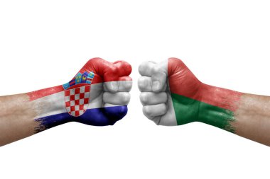 Two hands punch to each others on white background. Country flags painted fists, conflict crisis concept between croatia and madagascar