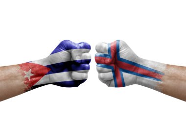 Two hands punch to each others on white background. Country flags painted fists, conflict crisis concept between cuba and faroe islands