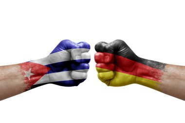 Two hands punch to each others on white background. Country flags painted fists, conflict crisis concept between cuba and germany