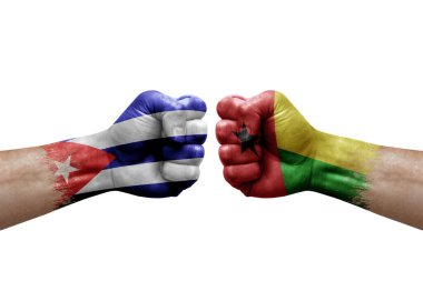 Two hands punch to each others on white background. Country flags painted fists, conflict crisis concept between cuba and guinea-bissau