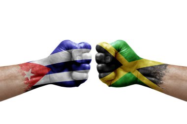 Two hands punch to each others on white background. Country flags painted fists, conflict crisis concept between cuba and jamaica