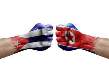 Two hands punch to each others on white background. Country flags painted fists, conflict crisis concept between cuba and north korea