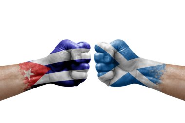 Two hands punch to each others on white background. Country flags painted fists, conflict crisis concept between cuba and scotland