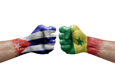 Two hands punch to each others on white background. Country flags painted fists, conflict crisis concept between cuba and senegal