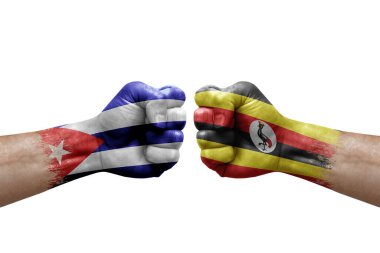 Two hands punch to each others on white background. Country flags painted fists, conflict crisis concept between cuba and uganda