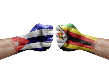 Two hands punch to each others on white background. Country flags painted fists, conflict crisis concept between cuba and zimbabwe