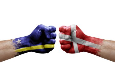 Two hands punch to each others on white background. Country flags painted fists, conflict crisis concept between curacao and denmark