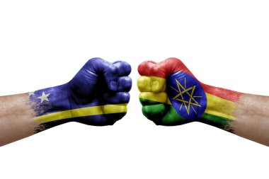 Two hands punch to each others on white background. Country flags painted fists, conflict crisis concept between curacao and ethiopia