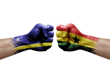 Two hands punch to each others on white background. Country flags painted fists, conflict crisis concept between curacao and ghana