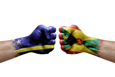 Two hands punch to each others on white background. Country flags painted fists, conflict crisis concept between curacao and grenada