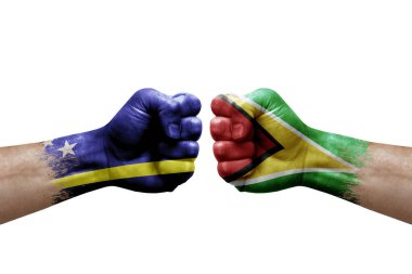 Two hands punch to each others on white background. Country flags painted fists, conflict crisis concept between curacao and guyana