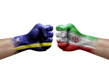 Two hands punch to each others on white background. Country flags painted fists, conflict crisis concept between curacao and iran