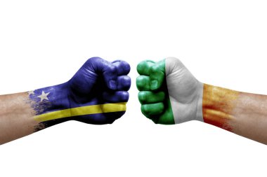 Two hands punch to each others on white background. Country flags painted fists, conflict crisis concept between curacao and ireland