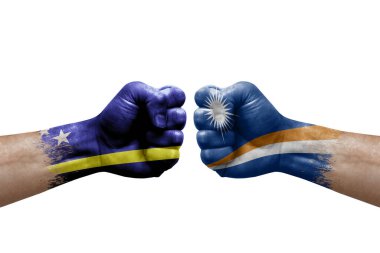 Two hands punch to each others on white background. Country flags painted fists, conflict crisis concept between curacao and marshall islands