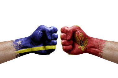 Two hands punch to each others on white background. Country flags painted fists, conflict crisis concept between curacao and montenegro