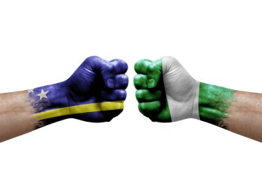 Two hands punch to each others on white background. Country flags painted fists, conflict crisis concept between curacao and nigeria