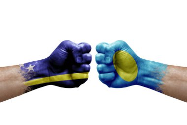 Two hands punch to each others on white background. Country flags painted fists, conflict crisis concept between curacao and palau