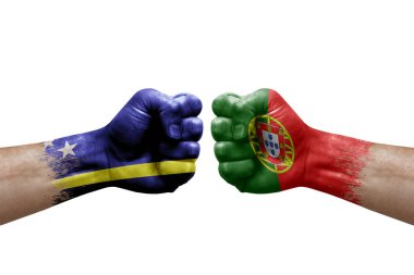 Two hands punch to each others on white background. Country flags painted fists, conflict crisis concept between curacao and portugal