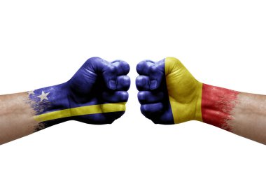 Two hands punch to each others on white background. Country flags painted fists, conflict crisis concept between curacao and romania