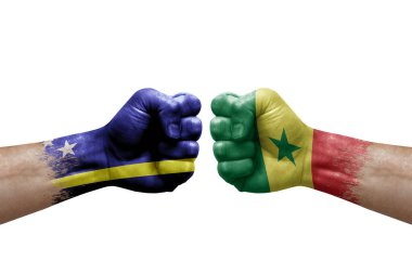 Two hands punch to each others on white background. Country flags painted fists, conflict crisis concept between curacao and senegal