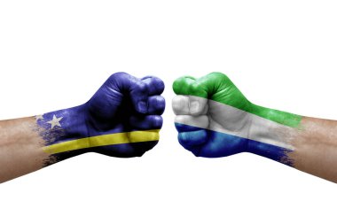 Two hands punch to each others on white background. Country flags painted fists, conflict crisis concept between curacao and sierra leone