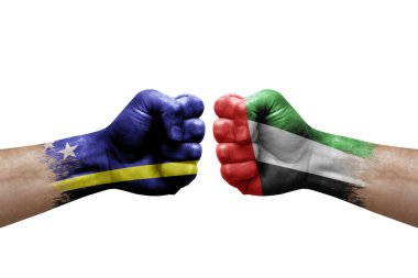 Two hands punch to each others on white background. Country flags painted fists, conflict crisis concept between curacao and united arab emirates