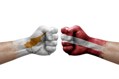 Two hands punch to each others on white background. Country flags painted fists, conflict crisis concept between cyprus and latvia
