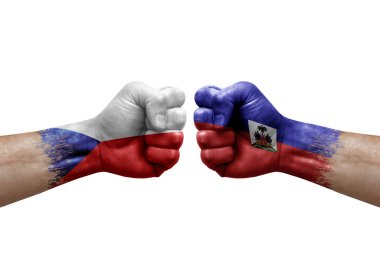 Two hands punch to each others on white background. Country flags painted fists, conflict crisis concept between czechia and haiti