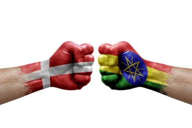 Two hands punch to each others on white background. Country flags painted fists, conflict crisis concept between denmark and ethiopia