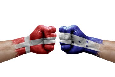 Two hands punch to each others on white background. Country flags painted fists, conflict crisis concept between denmark and honduras